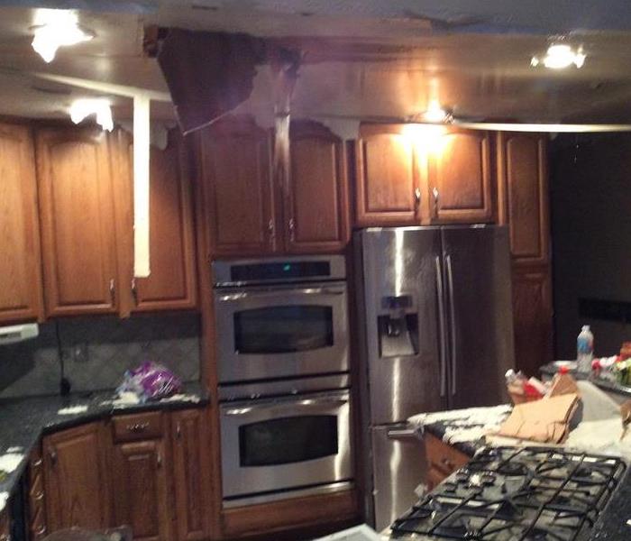 A kitchen where the ceiling has collapsed due to a broken pipe