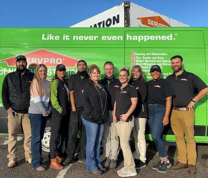 employees standing in front of a servpro van